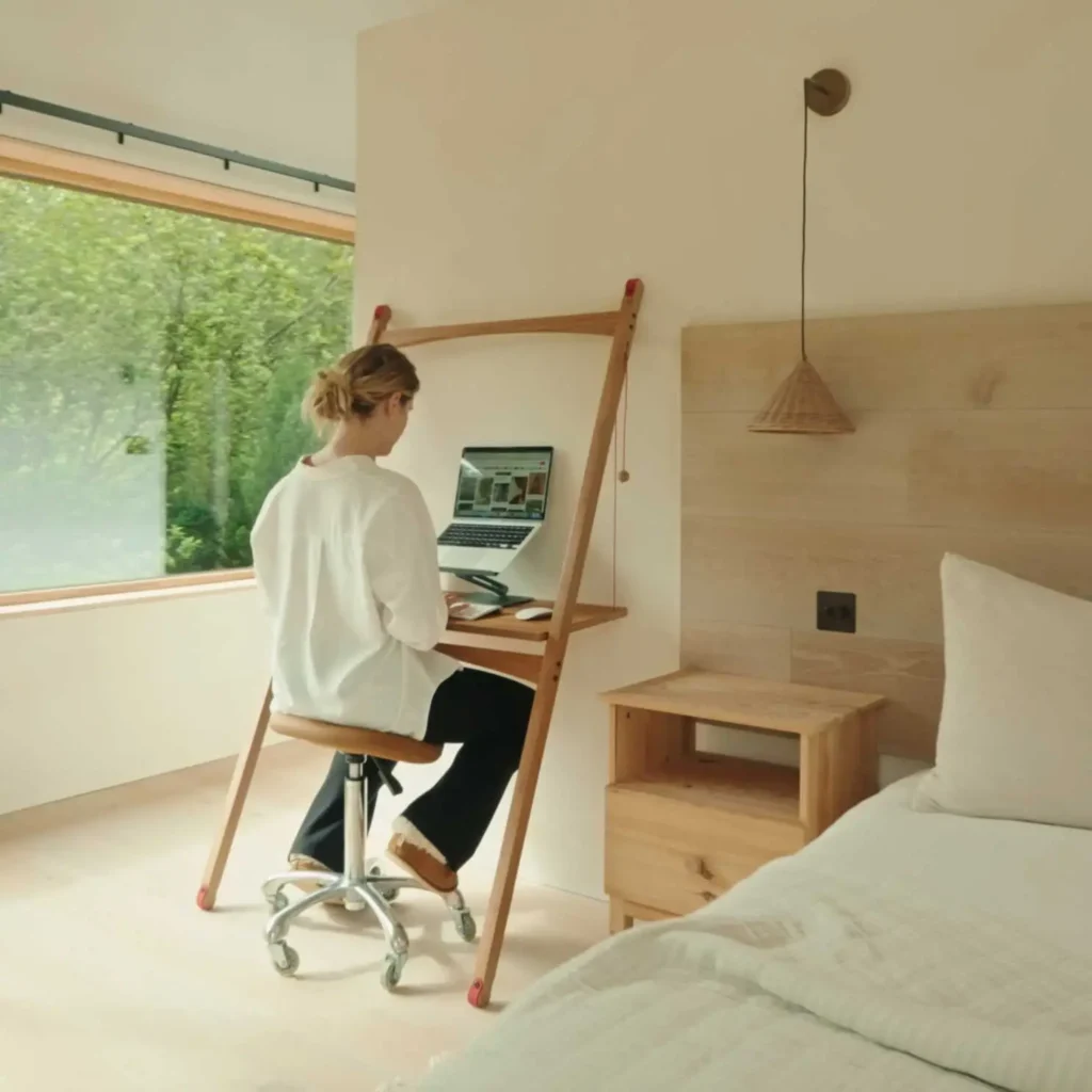 Female sitting working on a Leandesk in the bedroom