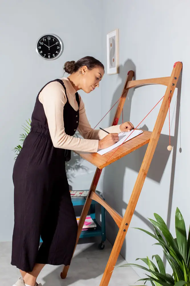 Adjustable angle folding desk for artists set up for drawing and sketching in a minimal home studio