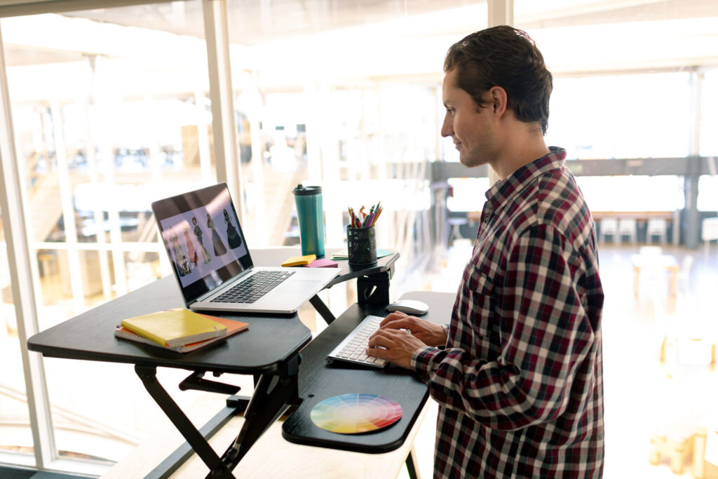 Standing desk converter on a kitchen table — adjustable height desk idea for small spaces without a dedicated office