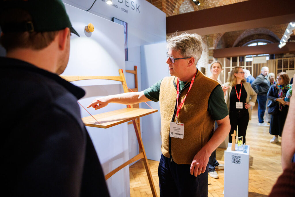 Designer, Henry Swanzy demonstrates the Leandesk sit-stand desk at Clerkenwell Design Week.